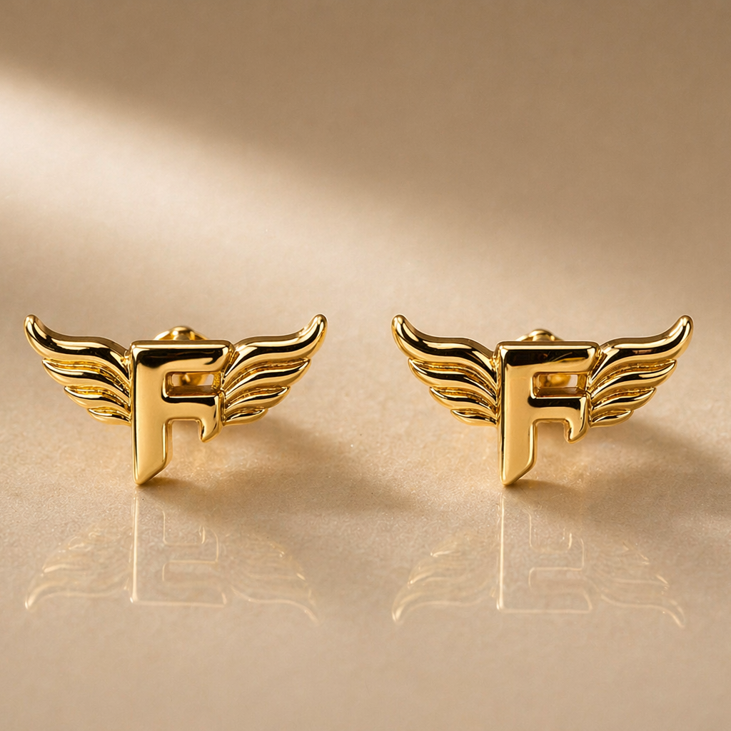 Gold winged 'F' earrings on a gold background