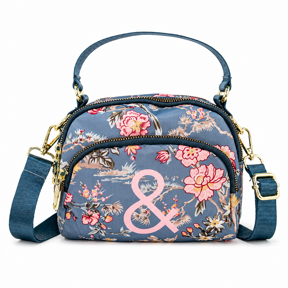 Floral patterned handbag with a pink ampersand on a white background