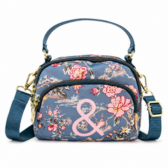 Floral patterned handbag with a pink ampersand on a white background
