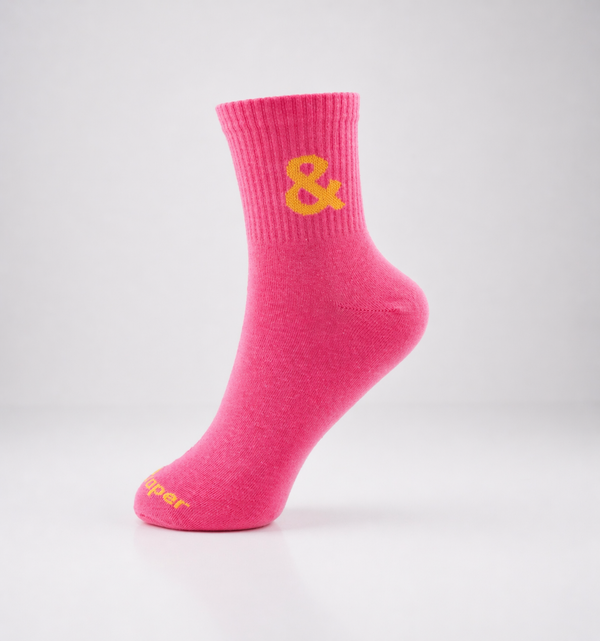 Pink sock with a yellow ampersand on a light gray background