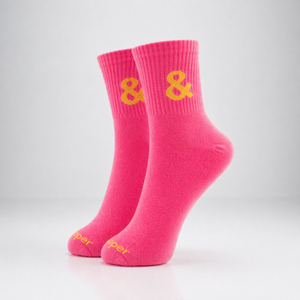 Pair of pink socks with yellow ampersand symbol on a light gray background