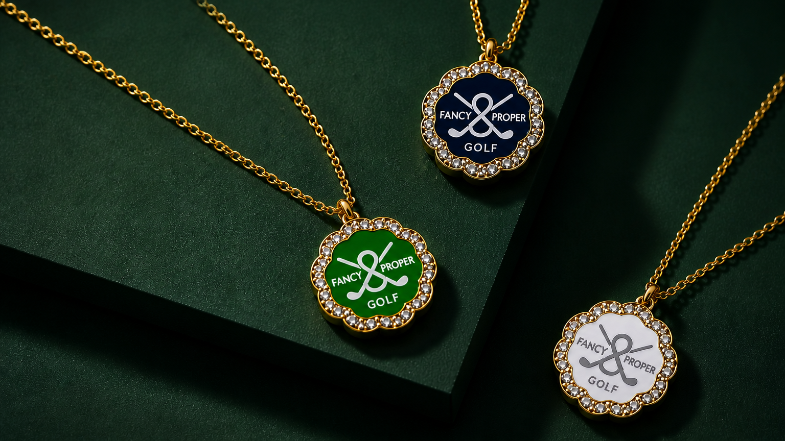 Three gold necklaces with round pendants on a dark green background