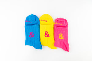 Three colorful socks with ampersand symbols on a white background