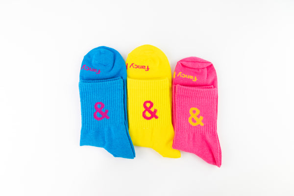 Three colorful socks with ampersand symbols on a white background