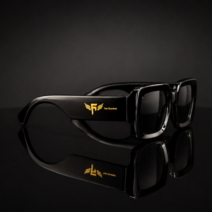Black sunglasses with gold and silver logo on a black reflective surface