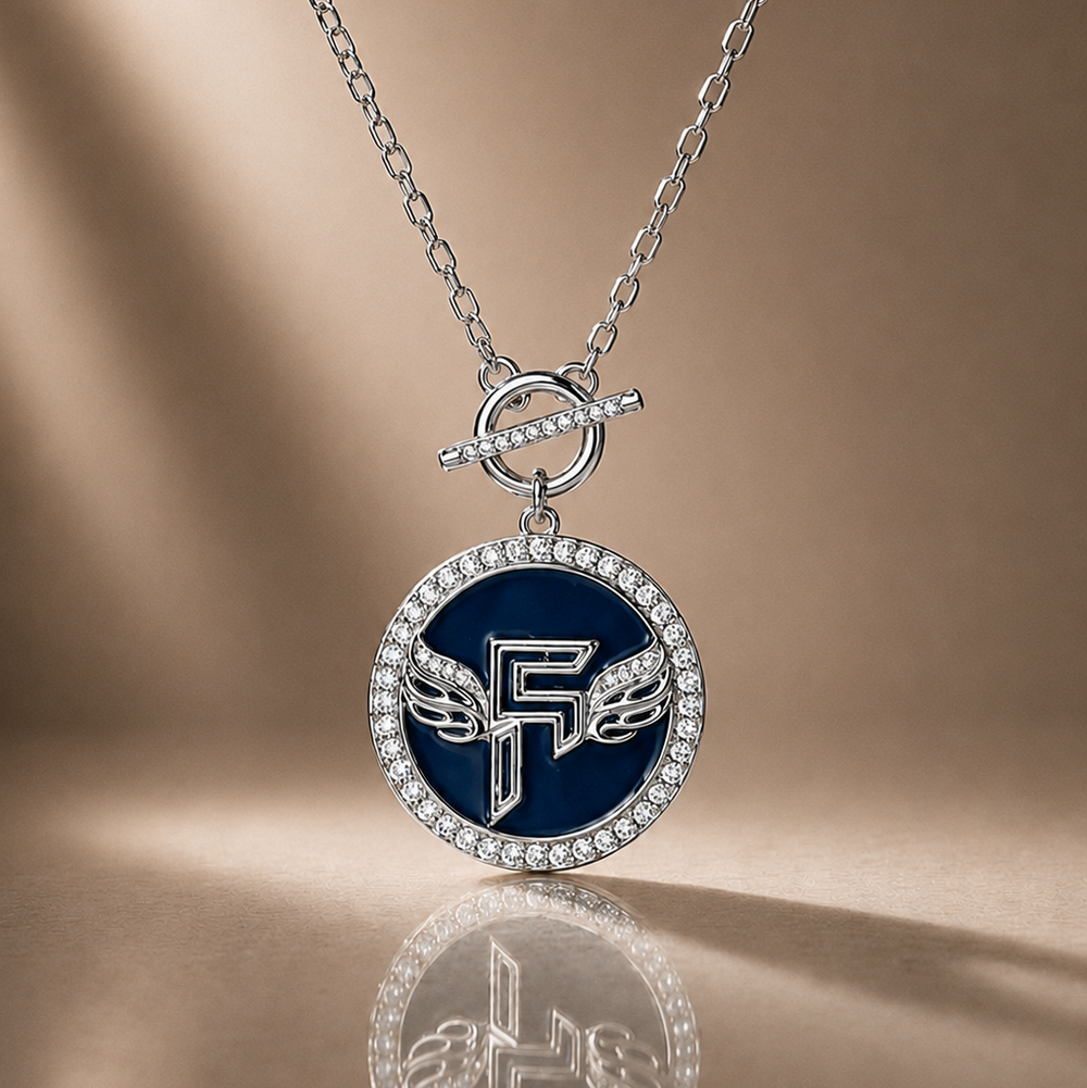 Necklace with a blue pendant featuring a logo on a reflective surface.