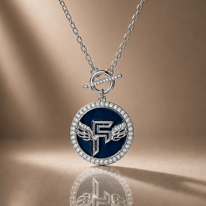 Necklace with a blue pendant featuring a logo on a reflective surface.