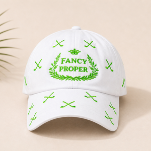 White cap with green embroidery on a beige background