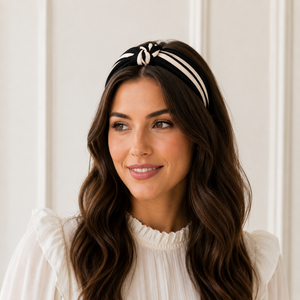 Woman wearing a black and white striped headband against a white background