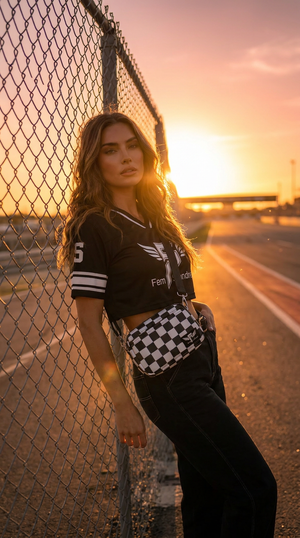 Woman leaning against a chain-link fence with a sunset in the background