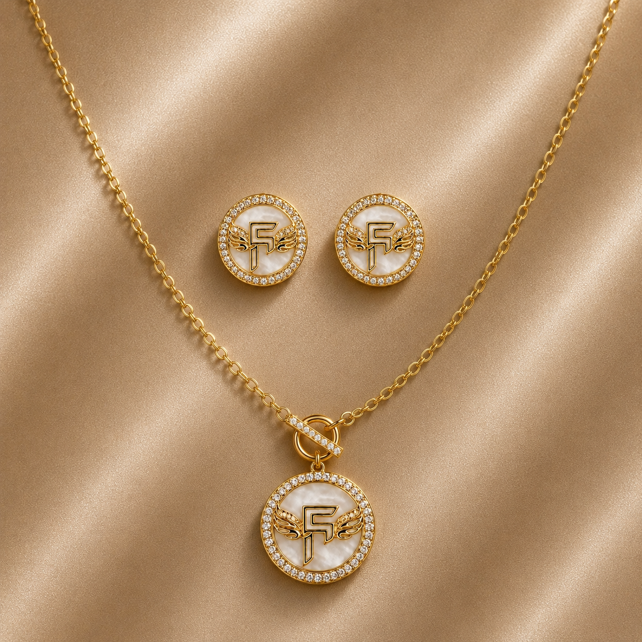 Gold jewelry set with necklace and earrings on a beige fabric background Main image