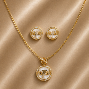 Gold jewelry set with necklace and earrings on a beige fabric background