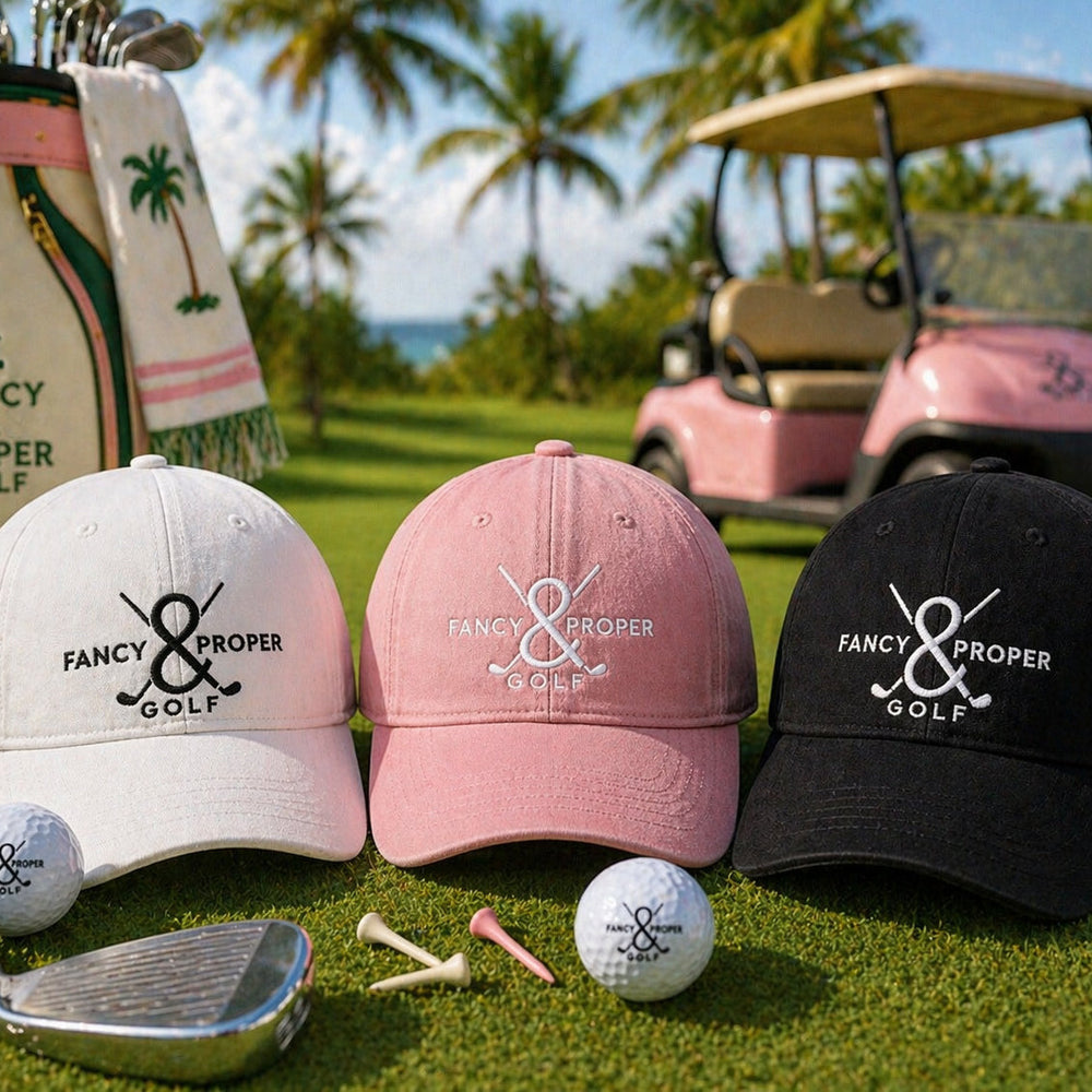 Three golf caps with 'Fancy & Proper Golf' logo on a golf course with golf balls and club.