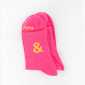 Pink socks with yellow text on a white background