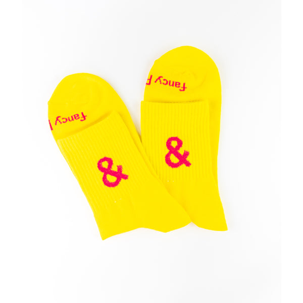 Yellow socks with pink ampersand and text on a white background